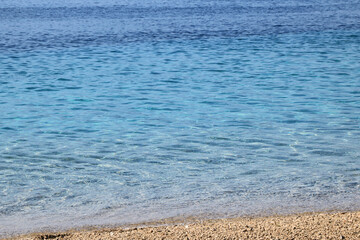 the blue sea and pebbled beach of the famous golden horn or Zlatni rat beach in Bol, island Brac, Croatia