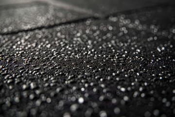 A detailed close-up shot of textured rubber flooring in a fitness studio, showcasing water droplets on the surface