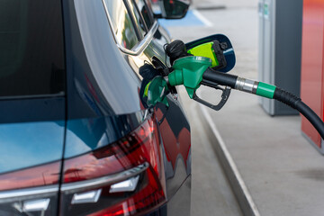 Filling the car with petrol. Car at a petrol station. Fuel gun is inserted into the tank. High quality photo