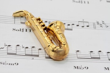Obraz premium miniature saxophone toy on a music sheet background