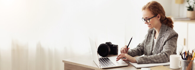 Young reporter transfering image data from camera to laptop, ready to write new article