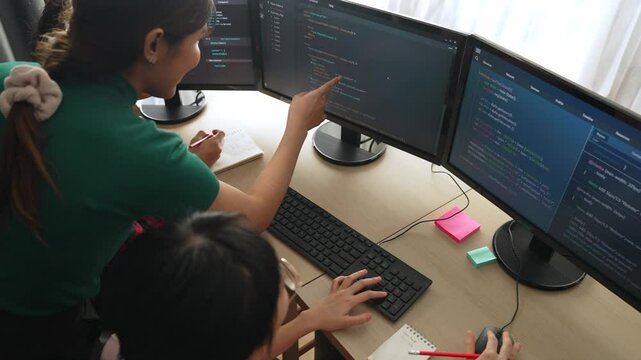 Back end software developer engineer for computer programming working together on debugging writing computing code, solving complex algorithms display on monitor in office. Burgeoning