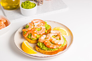 Shrimps on toast or sandwich with avocado and lemon. Breakfast concept. Bruschetta. 