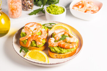Shrimps on toast or sandwich with avocado and lemon. Breakfast concept. Bruschetta. 