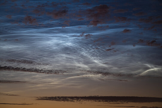 Detailed image of noctilucent clouds (NLC) in the forms of billows, curls and waves, during a midsummer night in June.