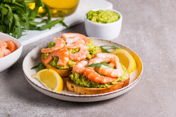 Shrimps on toast or sandwich with avocado and lemon. Breakfast concept. Bruschetta. 