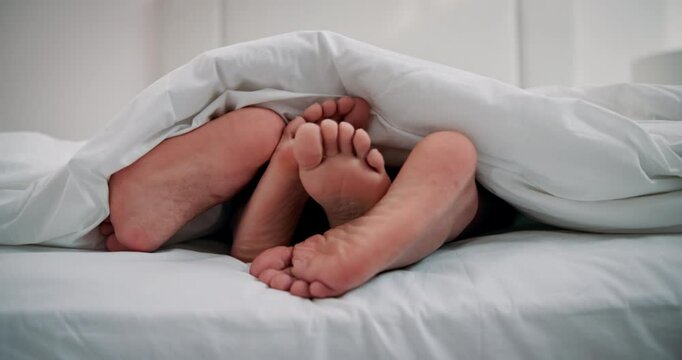 Sex, feet or couple in bed for love, intimacy or relax on weekend in hotel room. Honeymoon, people or cuddle in bedroom for marriage, romance or sleeping with partner for trust, commitment or comfort