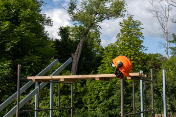 Kaska instalatora na rusztowaniu, przy konstrukcji naziemnej instalacji fotowoltaicznej 