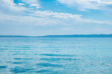 Obraz premium beautiful calm blue sea with clouds in sky