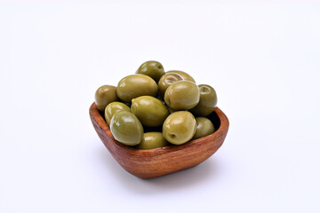 wooden bowl with green olives on a white background close-up