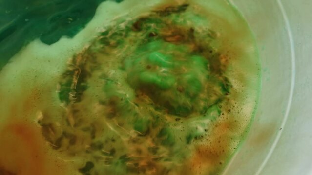A closeup video capturing the captivating chemical reaction of copper and nitric acid. Witness the vibrant colors and swirling patterns as the two substances interact