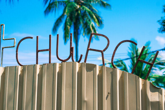 Iron "church" letters on the white fence.