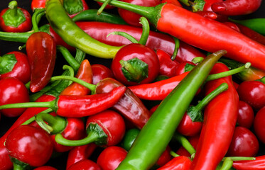 Pile of different hot peppers. Green and red hot chili peppers background