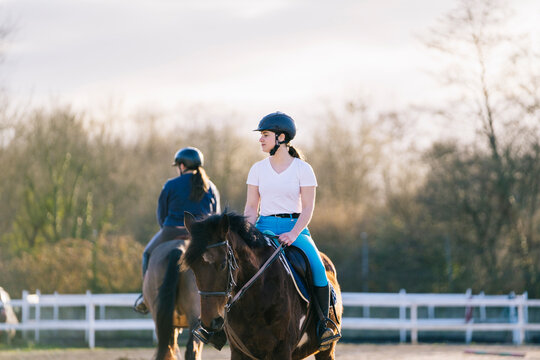 Young teenage ladies riding horses in ranch