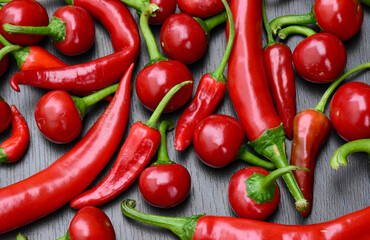 Pile of different red hot peppers on dark background