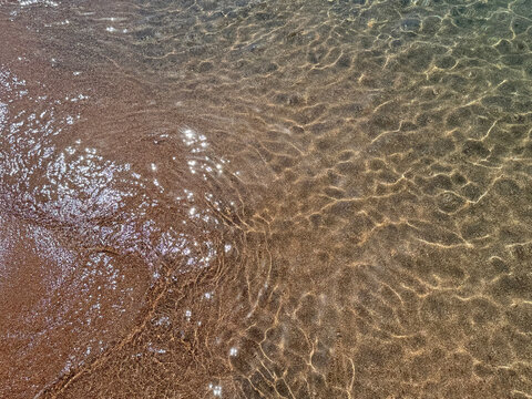  Clear sea water with sun glare on sandy beach