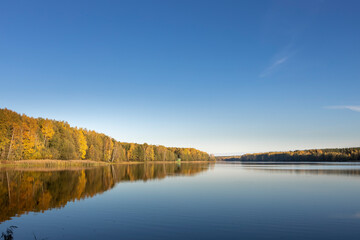 A calm lake with a blue sky in the background