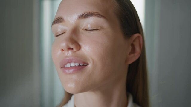 Girl spraying thermal water in ideal skin. Closeup beauty model looking camera