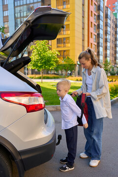 a mother drives her son to school in her car. 