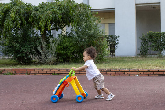 first steps, baby learning to walk pushing baby walker