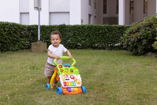 first steps, happy baby learning to walk using baby walker