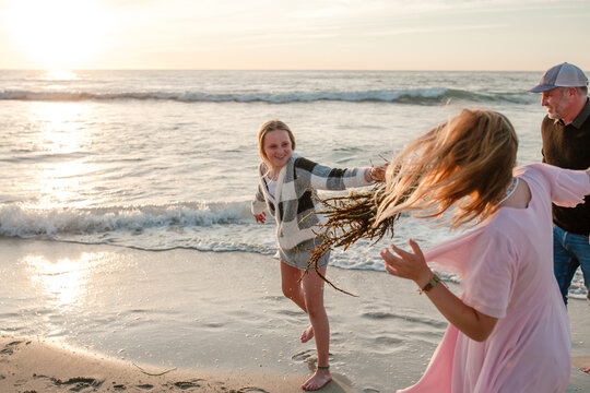 Father with teenage daughters on the beach together