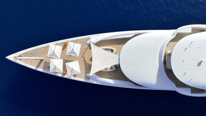 Aerial drone top down photo of luxury yacht with wooden deck anchored in deep blue Aegean sea,...