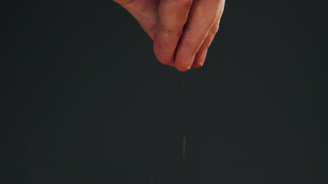Cumin or jeera seeds close-up. Man hand strewing seasoning cumin or jeera. Spice for food