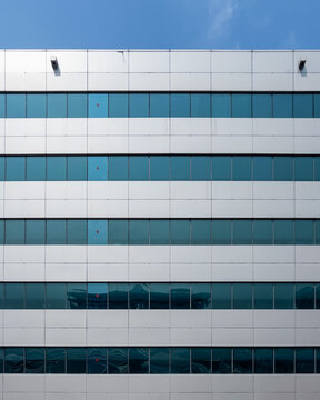 Rows of blue tint windows on a blue sky sunny day in Bangkok, Thailand