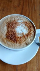 A white cappuccino cup on a wooden table