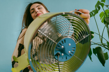 A young woman is holding a green fan