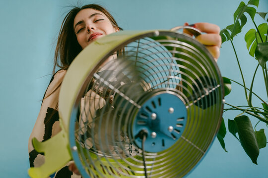 A young woman is holding a green fan