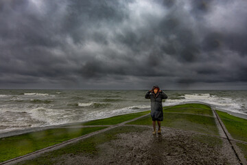 Femme sur la digue de Villers-sur-Mer un jour de tempête © Gerald Villena