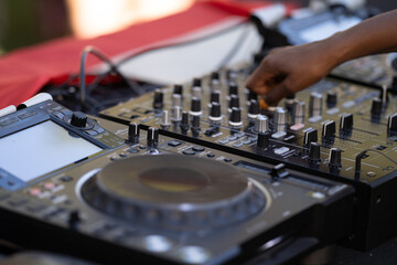 Naklejka premium close up to the dj hands with mixing console at the open air african festival in Lisbon