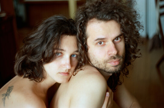 
man and woman nude hugging by the window