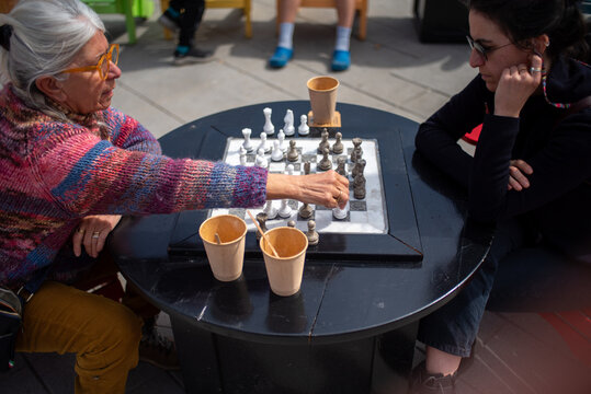 Senior mother and daughter paying chess outdoor