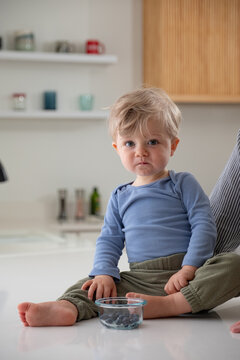 Portrait of todder sitting on kitchen counter..
