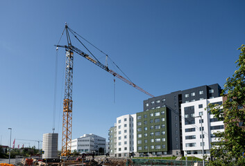 Fototapeta premium Construction of a multi-storey building with a crane on a background of blue sky in Reykjavik, Iceland