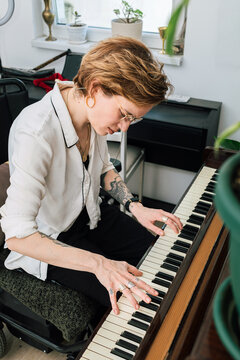 Woman composing music on a piano at home