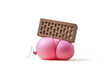 Pink ball bring compressed under weight of building stone