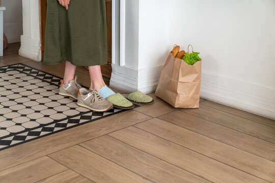 Woman Changing Shoes at Doorway