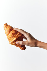 Person holding a croissant on white background