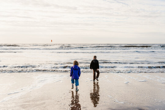 2 kids walking on the beach during sunset