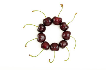 Cherries laid out in a frame on a white background