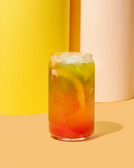A vibrant tropical cocktail with ice, perfect for summer refreshment and beach parties against a colorful background