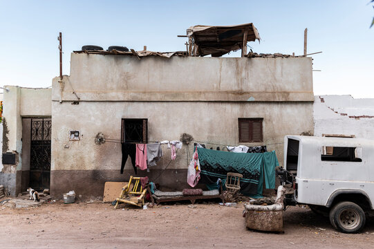 Simple house exterior with drying laundry and furniture