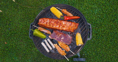 CLOSE UP, TOP DOWN: Grilling assortment of seasoned meat and fresh vegetables © helivideo