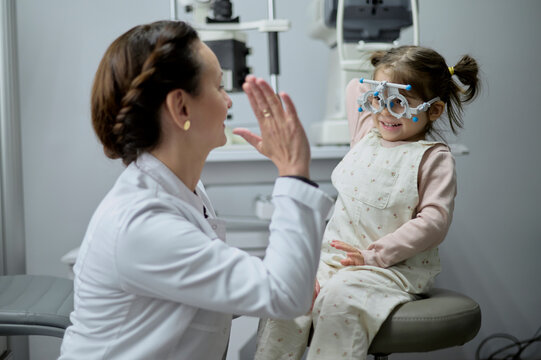Little girl getting eye exam at modern clinic