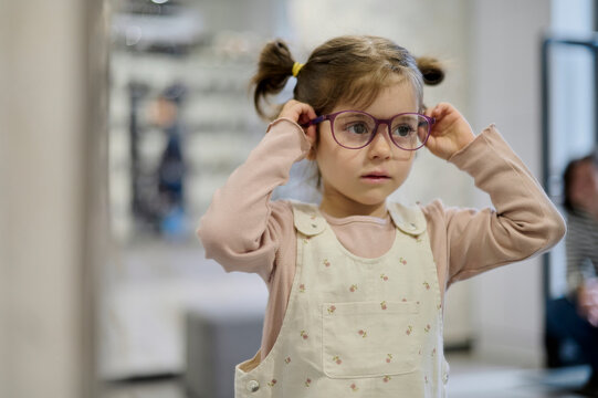 little girl with glasses in optical store