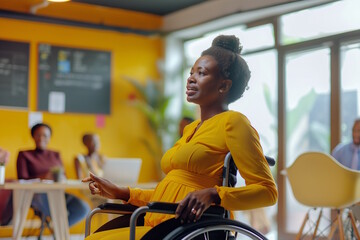 African American pregnant woman in wheelchair during a casual office meeting. Team discussion, inclusivity, maternity. Concept for teamwork, empowerment, International Day of Persons with Disabilities